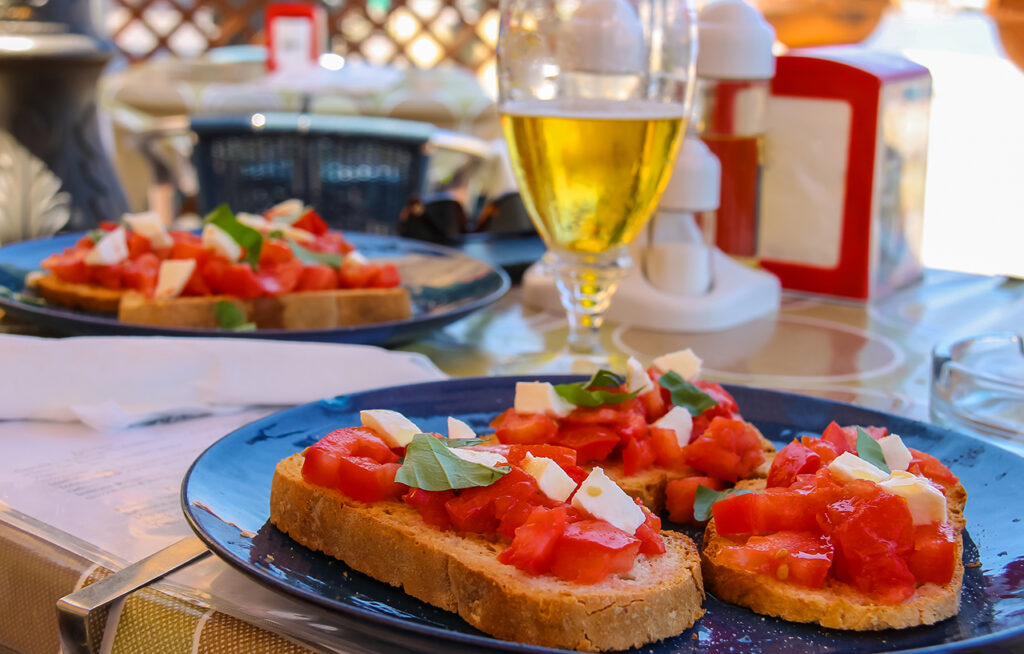 Bruschettas con tomate y queso en mesa de restaurante.